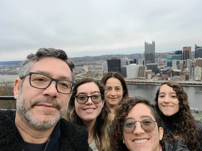 friends posing with the pittsburgh skyline in the background