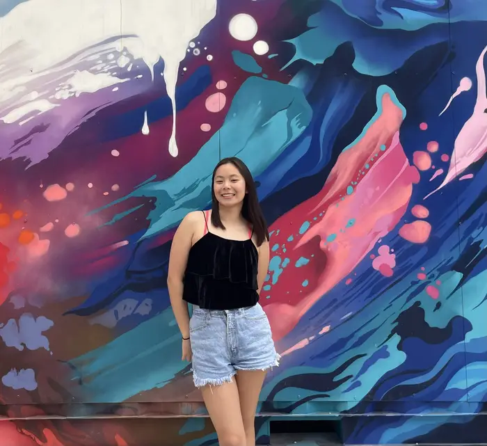 Student posing in front of a wall