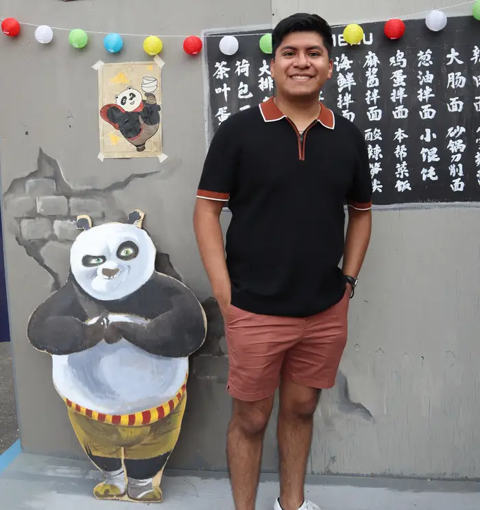 Eric standing in front of a "Kung-Fu Panda" booth at Carnival