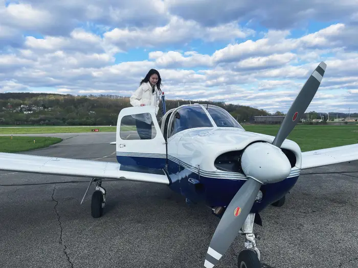Sofia standing next to a plane as part of Flying Club.