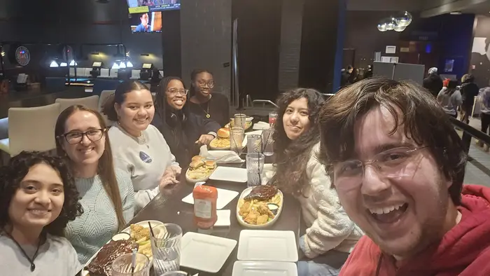 Giancarlo and friends smile for a photo at dinner.