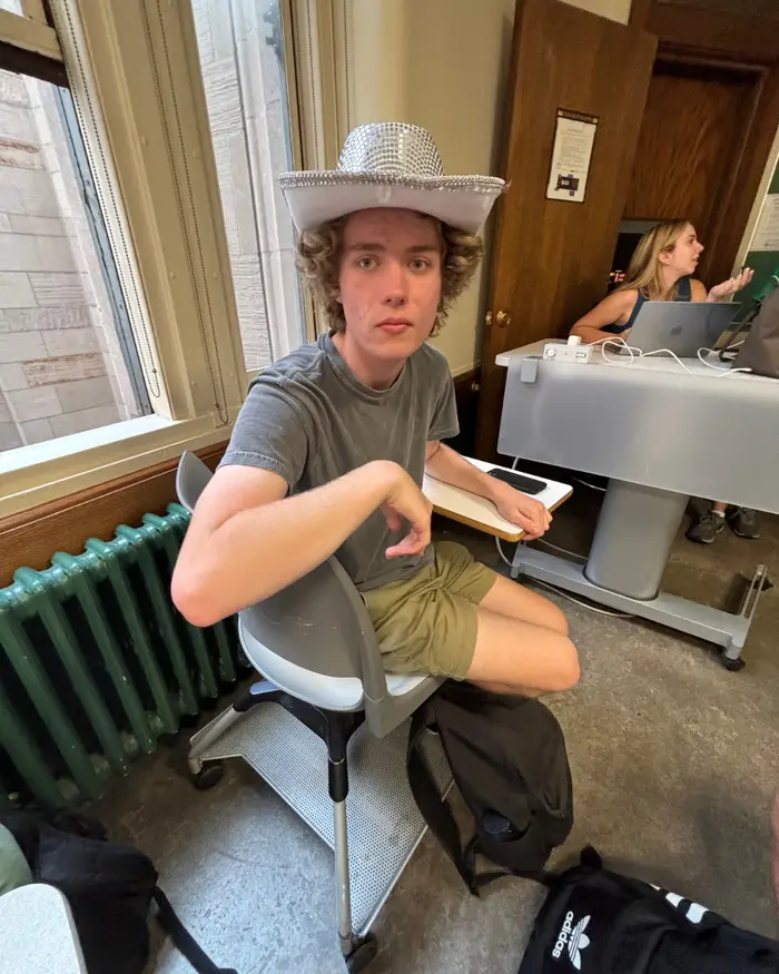 Elliot poses for a photo during a debate tournament where they had to wear cowboy hats