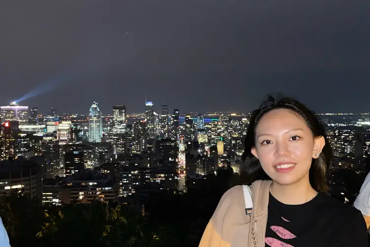 student smiling with cityscape in background