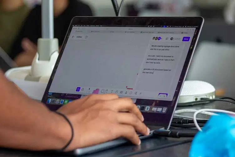 Image of a laptop with a student's hand typing